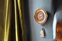 closeup of blue wall with miniature painting
