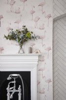 Bathroom detail showing bath taps, fireplace and flamingo wallpaper.
