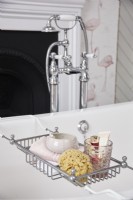 Rolltop bath detail showing bath rack with a natural sponge and beauty products.