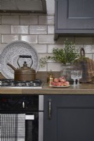 Kitchen detail showing dark grey cabinets, oven and vintage kettle.