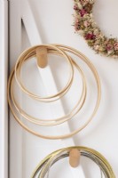 Detail of dried flower hoops hanging on wooden pegs