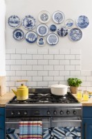 A display of blue and white vintage plates above a cooker