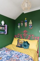 Painted red cane headboard against a green wall