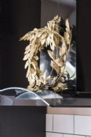 Golden wreath against black extractor fan - Kitchen detail