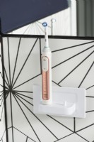 Detail of electric toothbrush on holder in modern bathroom
