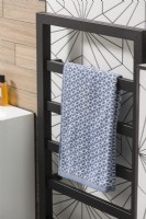 Patterned towel on modern black towel radiator - bathroom detail