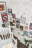 Display of framed paintings on staircase wall