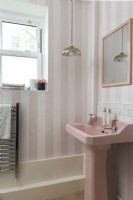 Retro bathroom with pink sink and striped wallpaper