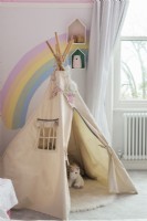 Play tepee tent in childrens room with rainbow painted on wall 