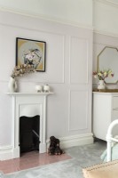 Small fireplace set in panelled wall of vintage style bedroom 