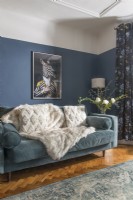 Modern artwork on wall of living room with split painted blue walls