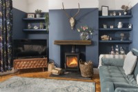 Lit wooden burning stove in dark blue painted living room