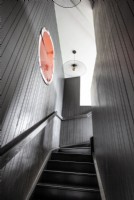 View up contemporary staircase with grey painted stairs and walls