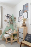 Corner of childs bedroom with wooden desk and stool
