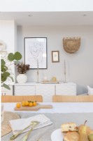 View across a dining table to a white sideboard with accessories