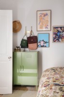 Corner of bedroom with cabinet, handbags and artwork