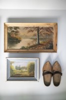 Vintage paintings and wooden shoes on wall - detail