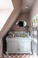 Dusky pink painted walls and vintage style vanity unit with sink 