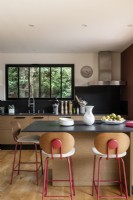 Black painted walls and worktop in wooden kitchen