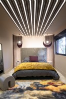Contemporary bedroom with strips of lighting around and above bed