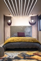 Patterned rug and modern lighting design in contemporary bedroom