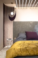 Marble headboard and contemporary lighting in modern bedroom