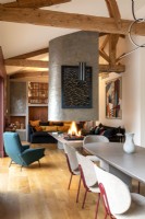 Central fireplace dividing contemporary living and dining areas