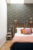 Salvaged wooden pallet used as headboard in eclectic bedroom