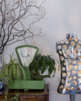 Old kitchen scale with plants and mannequin standing next to it