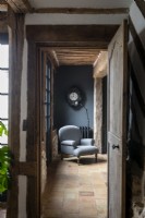 Antique grey chair in country hallway with stone tiled floor