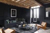Black painted modern country living room with swing next to window