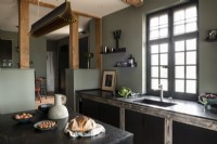 Contemporary country kitchen with green walls and black cabinets 