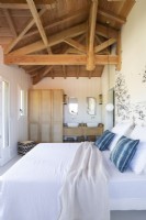 White country bedroom with ensuite bathroom and vaulted ceiling