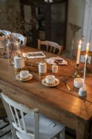 Detail of country dining room with coffee cups and lit candles