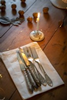 Silverware and napkin on wooden dining table - detail