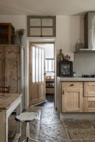 Country kitchen diner with distressed wooden furniture and stone floor