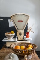Vintage weighing scales on wooden kitchen worktop with basket 