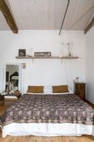 Country bedroom with white painted wooden ceiling and walls