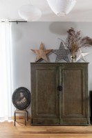 Old wooden cabinet with star ornaments and old portrait painting