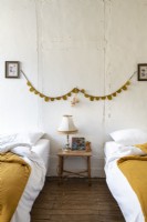 Decorative bunting in rustic bedroom with twin beds 