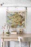 Wall mounted map above pale pink desk in country study