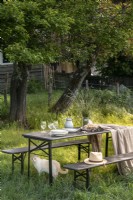 Garden table and benches in country garden