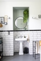 Sink and mirror in recess of black and white bathroom