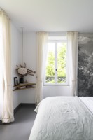 Modern grey and white bedroom with decorative mural 