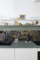 Detail of modern kitchen concrete worktop and marble splashback