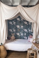 Childrens bedroom with floral feature wall and canopy over bed