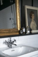 Detail of bathroom sink with gilded mirror