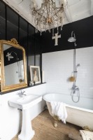 Black and white country bathroom with chandelier and gilded mirror