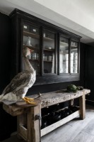 Taxidermy goose in black and grey kitchen next to dresser