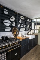 Black painted modern country kitchen with display of white plates